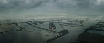 Movie still from “Suicide Squad” (2016), directed by David Ayer – An aerial view of an airport runway in the middle of a flooded area; Extreme Wide shot, High angle
