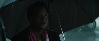 Movie still from “Suicide Squad” (2016), directed by David Ayer – A woman with a pink scarf is holding an umbrella; Close Up shot, Low angle