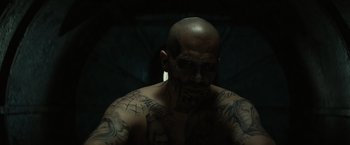 Movie still from “Suicide Squad” (2016), directed by David Ayer – A man that has a lot of tattoos on his body; Close Up shot, High angle