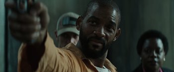 Movie still from “Suicide Squad” (2016), directed by David Ayer – A person with a hat; Close Up shot, Low angle