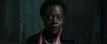 Movie still from “Suicide Squad” (2016), directed by David Ayer – A person wearing a jacket and a pink scarf; Close Up shot, Over the shoulder angle