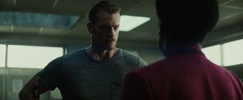 Movie still from “Suicide Squad” (2016), directed by David Ayer – A person in a room with another person; Close Up shot, Over the shoulder angle