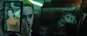 Movie still from “Suicide Squad” (2016), directed by David Ayer – A man with green hair and a green face; Close Up shot, Over the shoulder angle
