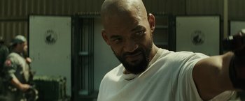Movie still from “Suicide Squad” (2016), directed by David Ayer – A man with a beard and a white t - shirt; Close Up shot, Low angle