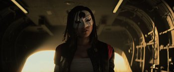 Movie still from “Suicide Squad” (2016), directed by David Ayer – A woman wearing a white mask and a black jacket; Close Up shot, Low angle