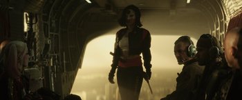 Movie still from “Suicide Squad” (2016), directed by David Ayer – A woman with a mask holding a sword; Medium shot, Over the shoulder angle
