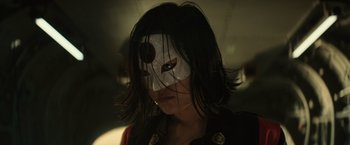 Movie still from “Suicide Squad” (2016), directed by David Ayer – A woman with a mask on her face; Close Up shot, Low angle