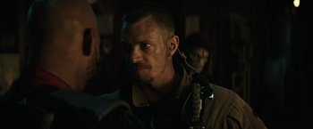 Movie still from “Suicide Squad” (2016), directed by David Ayer – A person with a microphone in his ear; Close Up shot, Over the shoulder angle