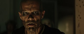 Movie still from “Suicide Squad” (2016), directed by David Ayer – A man with his face painted like a skull; Close Up shot, Over the shoulder angle