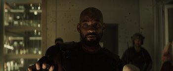 Movie still from “Suicide Squad” (2016), directed by David Ayer – A man with a beard is looking at the camera; Close Up shot, Low angle