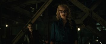 Movie still from “Suicide Squad” (2016), directed by David Ayer – A woman with glasses standing next to a man; Medium shot, Over the shoulder angle