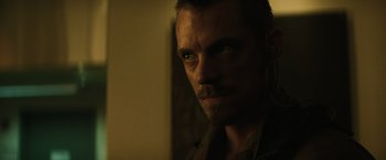 Movie still from “Suicide Squad” (2016), directed by David Ayer – A person looking at the camera; Close Up shot, Low angle