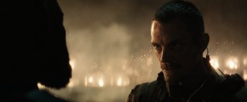 Movie still from “Suicide Squad” (2016), directed by David Ayer – A person in a field; Close Up shot, Over the shoulder angle