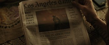 Movie still from “Suicide Squad” (2016), directed by David Ayer – A newspaper with a picture of a fire fighter on it; Extreme Close Up shot, High angle