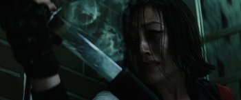 Movie still from “Suicide Squad” (2016), directed by David Ayer – A woman holding a knife in front of her face; Close Up shot, Low angle