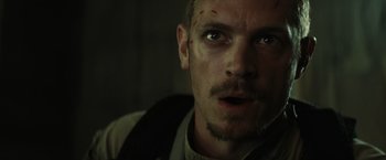 Movie still from “Suicide Squad” (2016), directed by David Ayer – A person looking at the camera; Close Up shot, Low angle