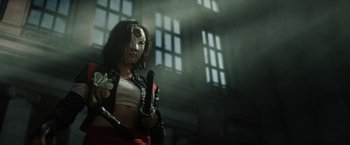 Movie still from “Suicide Squad” (2016), directed by David Ayer – A woman with a mask holding a pair of knives; Medium shot, Low angle