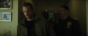 Movie still from “Suicide Squad” (2016), directed by David Ayer – A group of men standing next to each other in a room; Close Up shot, Over the shoulder angle