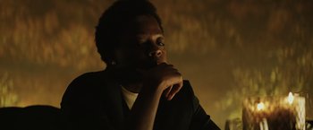 Movie still from “Suicide Squad” (2016), directed by David Ayer – A person in a dark room with their hand on his chin; Close Up shot, Low angle