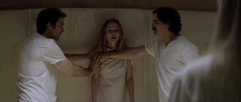 Movie still from “Suitable Flesh” (2023), directed by Joe Lynch – A man and a woman in a white dress; Medium shot, Over the shoulder angle