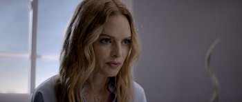 Movie still from “Suitable Flesh” (2023), directed by Joe Lynch – A person with long blonde hair; Close Up shot, Over the shoulder angle