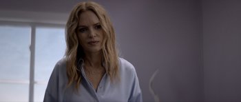 Movie still from “Suitable Flesh” (2023), directed by Joe Lynch – A woman with long blonde hair is wearing a blue shirt; Close Up shot, Over the shoulder angle