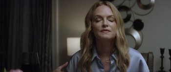 Movie still from “Suitable Flesh” (2023), directed by Joe Lynch – A woman with long blonde hair is sitting down; Close Up shot, Over the shoulder angle