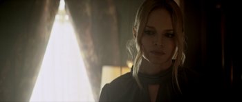 Movie still from “Suitable Flesh” (2023), directed by Joe Lynch – A woman with blonde hair wearing a black shirt; Close Up shot, Over the shoulder angle