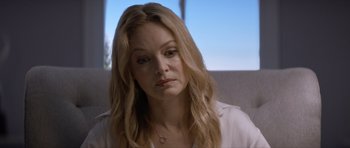 Movie still from “Suitable Flesh” (2023), directed by Joe Lynch – A person with long blonde hair; Close Up shot, Over the shoulder angle