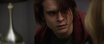 Movie still from “Suitable Flesh” (2023), directed by Joe Lynch – A person with long brown hair; Close Up shot, Over the shoulder angle