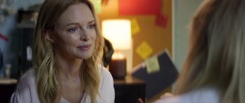 Movie still from “Suitable Flesh” (2023), directed by Joe Lynch – A beautiful woman sitting in front of a lamp; Close Up shot, Over the shoulder angle