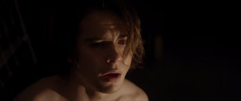 Movie still from “Suitable Flesh” (2023), directed by Joe Lynch – A man with long hair is looking at the camera; Close Up shot, Over the shoulder angle
