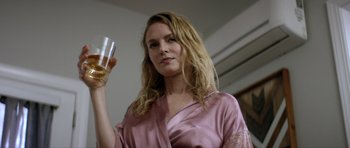 Movie still from “Suitable Flesh” (2023), directed by Joe Lynch – A woman holding a wine glass in her right hand; Close Up shot, Low angle