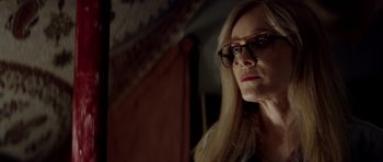 Movie still from “Suitable Flesh” (2023), directed by Joe Lynch – A person wearing glasses; Close Up shot, Over the shoulder angle