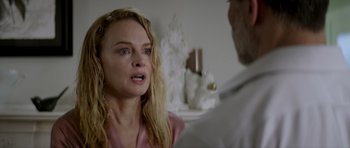 Movie still from “Suitable Flesh” (2023), directed by Joe Lynch – A woman in a pink shirt is talking to a man in a white shirt; Close Up shot, Over the shoulder angle