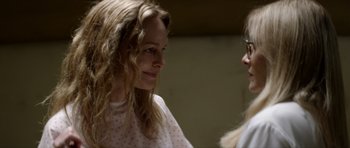 Movie still from “Suitable Flesh” (2023), directed by Joe Lynch – Two women are talking to each other in a room; Close Up shot, Over the shoulder angle