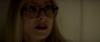 Movie still from “Suitable Flesh” (2023), directed by Joe Lynch – A person wearing glasses and looking sad; Close Up shot, Over the shoulder angle