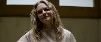 Movie still from “Suitable Flesh” (2023), directed by Joe Lynch – A person with long hair; Close Up shot, Over the shoulder angle