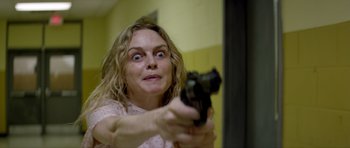 Movie still from “Suitable Flesh” (2023), directed by Joe Lynch – A woman holding a gun in front of a mirror; Close Up shot, High angle