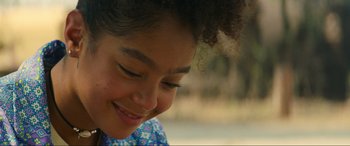 Movie still from “Summering” (2022), directed by James Ponsoldt – A young girl's face smiling; Close Up shot, Over the shoulder angle