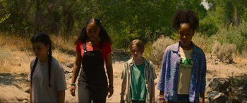 Movie still from “Summering” (2022), directed by James Ponsoldt – A group of people walking on a dirt road; Medium shot, Low angle