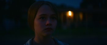 Movie still from “Summering” (2022), directed by James Ponsoldt – A young girl is standing in the dark outside; Close Up shot, Over the shoulder angle