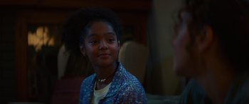 Movie still from “Summering” (2022), directed by James Ponsoldt – A young girl is smiling for the camera; Close Up shot, Over the shoulder angle