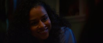 Movie still from “Summering” (2022), directed by James Ponsoldt – A person with curly black hair smiling; Close Up shot, Over the shoulder angle