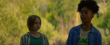 Movie still from “Summering” (2022), directed by James Ponsoldt – Two people standing next to each other in a forest; Medium shot, Over the shoulder angle