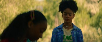 Movie still from “Summering” (2022), directed by James Ponsoldt – Two young women are standing in a forest; Close Up shot, Over the shoulder angle