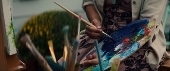 Movie still from “Summering” (2022), directed by James Ponsoldt – A person holding a paintbrush in their hand and painting; Close Up shot, Over the shoulder angle