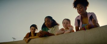Movie still from “Summering” (2022), directed by James Ponsoldt – A group of young people sitting on a ledge; Medium shot, Low angle