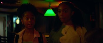 Movie still from “Summering” (2022), directed by James Ponsoldt – Two young women standing next to each other in front of a green light; Close Up shot, Low angle
