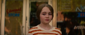 Movie still from “Summering” (2022), directed by James Ponsoldt – A young girl with brown hair wearing a striped shirt; Close Up shot, Over the shoulder angle